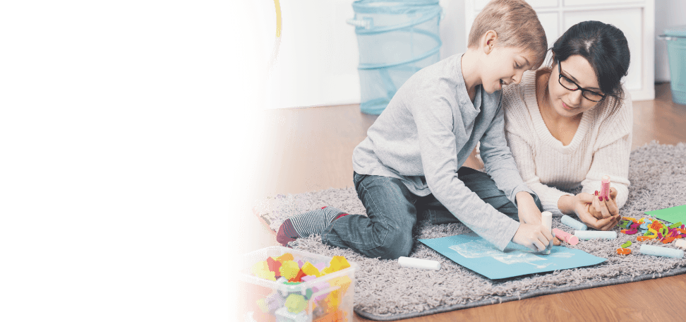 Woman playing with crafts on the floor with a boy